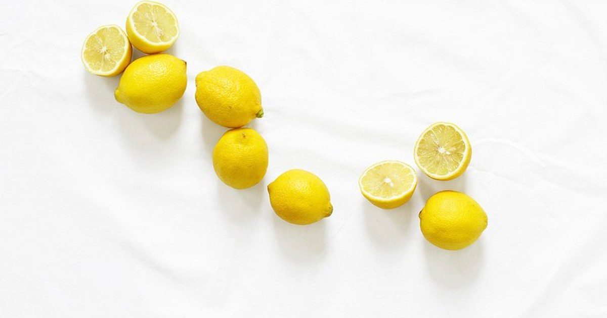 Limones enteros y partidos sobre fondo blanco