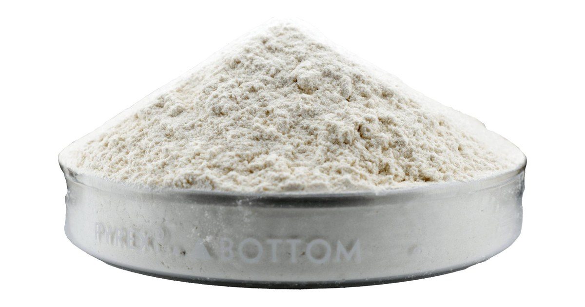 Goma xantana en polvo grado alimenticio en un recipiente de laboratorio
